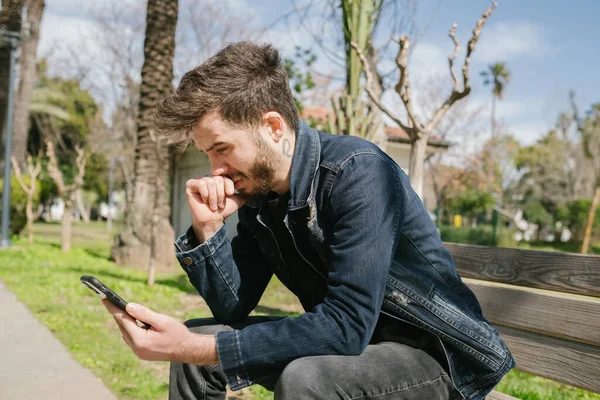 Genç erkek ne yazık ki telefonuna bakıyor. Ayrılık mesajı alan genç yetişkin harap olmuş, kötümser ve olumsuz bir izlenim bırakıyor.