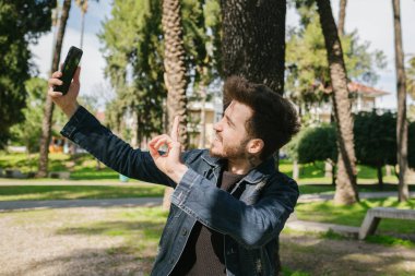 Selfie, sakallı yakışıklı adam selfie çekiyor, eğlenceli bir gülümseme ve sosyal medyada paylaşacak güzel bir poz.