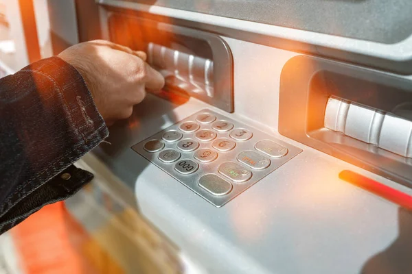 ATM, ATM 'den para çekmeye çalışan yetişkin bir erkek, güvenlik önlemleri ve QR ile para çekme yeteneği