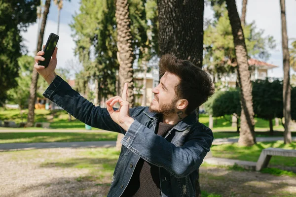 Selfie, sakallı yakışıklı adam selfie çekiyor, eğlenceli bir gülümseme ve sosyal medyada paylaşacak güzel bir poz.