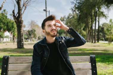 Düşünceli bir genç adam, elini kafasına koyar ve aklına bir fikir gelir, genç yetişkin durumdan kaçmak ister.