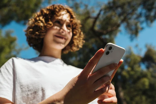 Boldog Fiatal Vörös Hajú Fehér Pólóban Kezében Egy Telefonnal Miközben — Stock Fotó