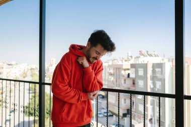 Dirsek ağrısı, genç adam dirseğini balkon korkuluklarına vurdu ve acı içinde, dişlerini gıcırdatan bir yetişkin.