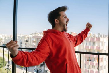 Neşeli adam, yakışıklı yetişkin haberlerden çok memnun ve sevinç, yüz ifadesi ve aşırı mutluluk için bağırıyor.