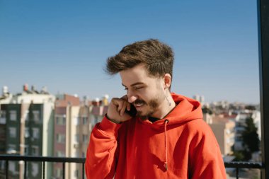 Telefon görüşmesi, yakışıklı genç adam telefonda konuşuyor. Mutlu görünen yetişkin insanlarla etkileşim