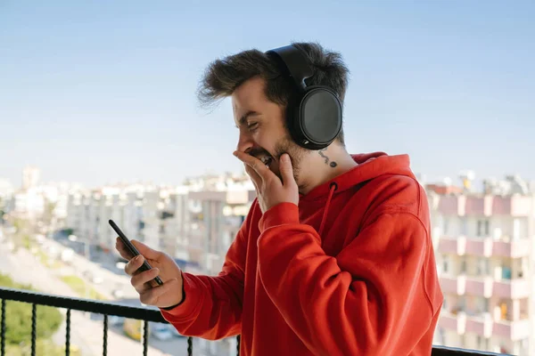 Rindo Jovem Voz Alta Mensagem Que Recebe Jovem Vestindo Fones — Fotografia de Stock