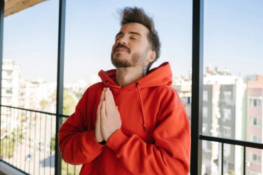 İnançlı, genç adam dua ederek ve olumlu enerji, meditasyon ve dini inanç göndererek elini sıktı