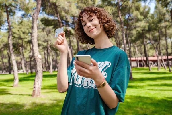 Ευτυχισμένη Νεαρή Κοκκινομάλλα Γυναίκα Πράσινο Μπλουζάκι Δείχνει Πλαστική Πιστωτική Κάρτα — Φωτογραφία Αρχείου