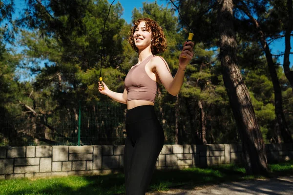 Beautiful Sports Redhead Girl Doing Exercises Jumping Rope City Park — стоковое фото