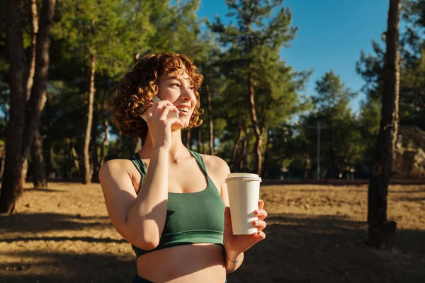 Young Redhead Woman Wearing Green Sports Bra Talking Friends Phone — Φωτογραφία Αρχείου