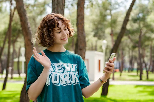 Весела Руда Жінка Зеленому Трійнику Стоїть Міському Парку Тримає Телефон — стокове фото