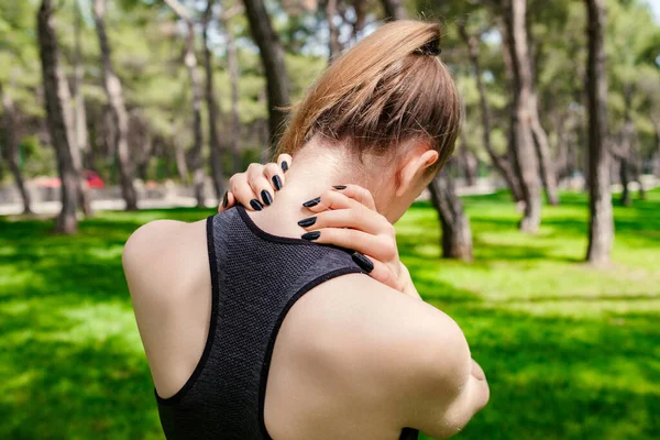 市内公園でスポーツウェアを着て若いブルネットの女性は 屋外で関節肩の腰痛 線維筋痛の概念を傷つける感じ リアビューを閉じます 医療と医療の概念 — ストック写真