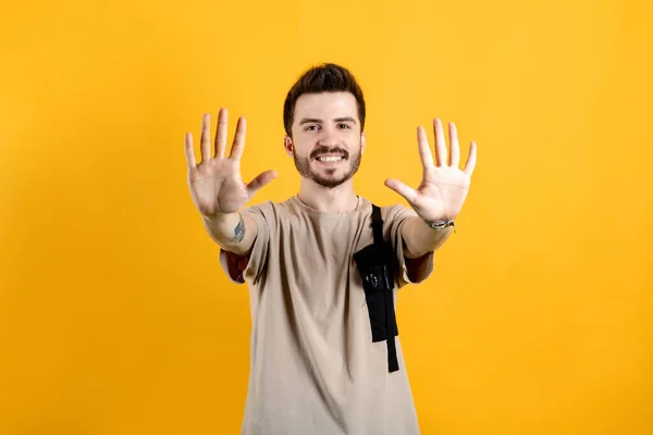 Młody Mężczyzna Uśmiecha Się Pewnie Beżowej Koszulce Pozując Żółtym Tle — Zdjęcie stockowe
