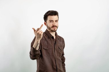 Handsome caucasian man wearing casual clothes posing isolated over white background showing middle finger doing fuck you bad expression.