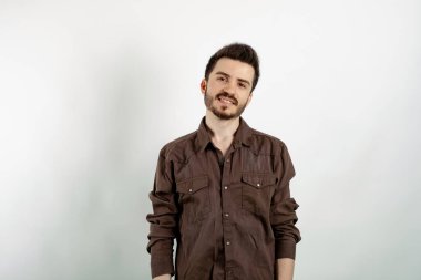Beyaz arka planda izole edilmiş kahverengi gömlek giyen beyaz bir adam gülümsüyor ve kameraya bakıyor. Pozitif kişi.