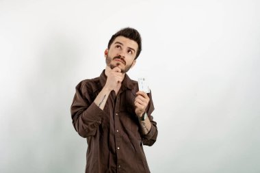 Beyaz arka planda soyutlanmış gibi görünen beyaz giysili yakışıklı beyaz bir adam kredi kartı ya da banka kartı taşıyordu.