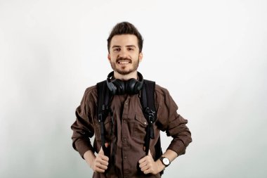 Yakışıklı, günlük kıyafetler giyen, beyaz arka planda soyutlanmış, üniversite konseptinde eğitim veren genç bir adam..