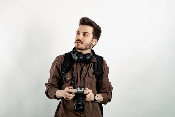 Кавказский Молодой Человек Рубашке Позирует Белом Фоне Держа Фотокамеру Отводя — стоковое фото