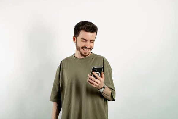 티셔츠를 배경에 고립된 스마트폰 화면을 페이지를 둘러보고 친구들 대화를 나누며 — 스톡 사진