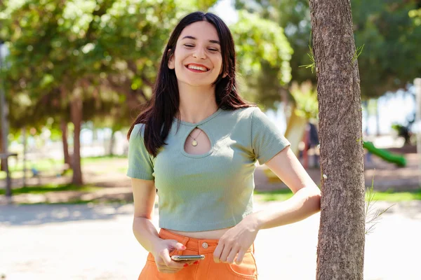 Cheerful Brunette Woman Wearing Tee Standing City Park Outdoors Using — Photo