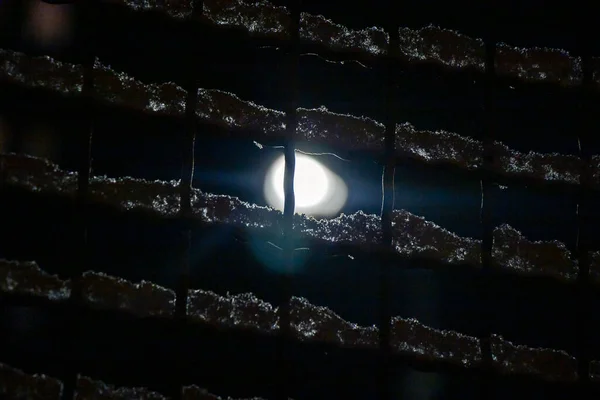Utcai Lámpa Éjszakai Fénye Hótakaróval Borított Rácson Keresztül — Stock Fotó