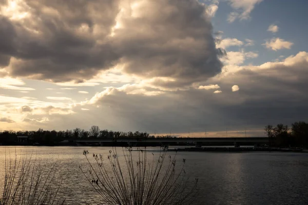 Nehrin üzerinde akşam manzarası. Güneş bulutların arasından ışıldıyor