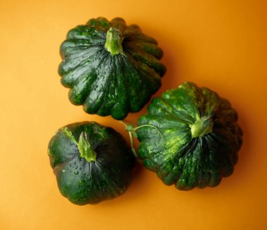 Turuncu arka planda yeşil pattypan kabakları