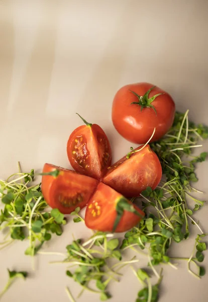 Dilimlenmiş domates, turp mikroyeşiliyle çevrili.