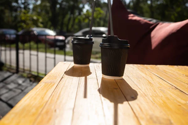 Two paper cup of coffee on the table outdoors