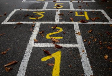 Asfalta boyanmış seksek. Düşen sonbahar yaprakları