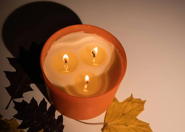 Karanlıkta üç fitili olan yanan mum. 