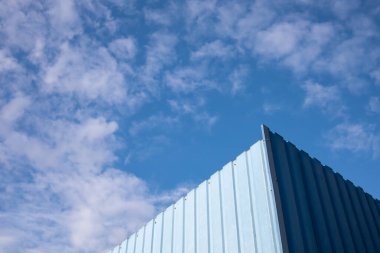 Açık bulutlu mavi bir gökyüzü manzarası. Kısmen görülebilir mavi çit