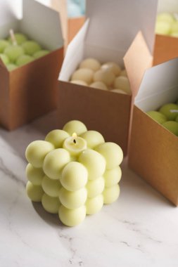 Yeşil, mavi ve beyaz baloncuk mumları mermer bir yüzey üzerinde kağıt kutularda