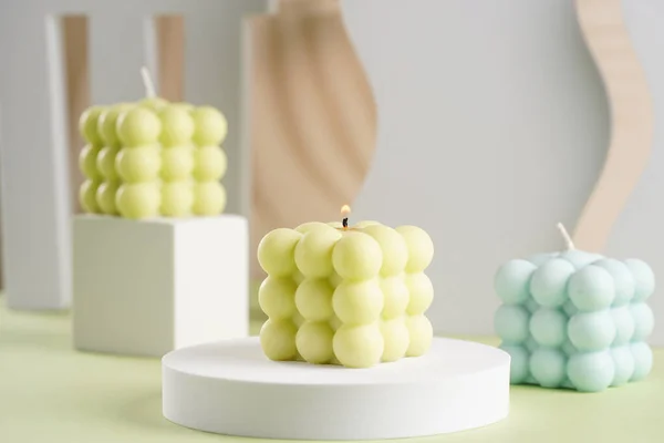 Drei Blaue Grüne Und Weiße Quadratische Blasenkerzen Auf Pastellgrüner Oberfläche — Stockfoto