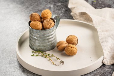 Gri beton tepside kahverengi cevizli metal bir kupa.