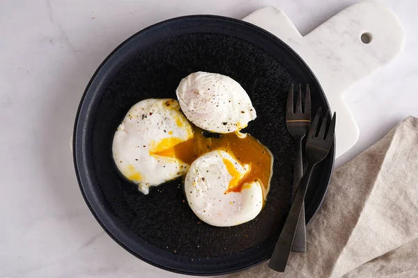 Tre Pocherade Ägg Med Äggula Svart Tallrik Marmorskiva Och Svarta — Stockfoto