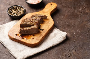 Tahtada pişmiş biftek dilimlenmiş beyaz ve siyah akranlar, kaba deniz tuzu.