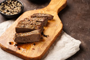 Tahtada pişmiş biftek dilimlenmiş beyaz ve siyah akranlar, kaba deniz tuzu.