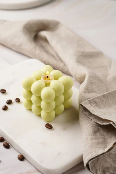 Eine Blassgrüne Quadratische Blasenkerze Auf Einem Marmor Küchentisch Zwischen Kaffeebohnen — Stockfoto