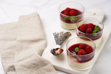 İtalyan sütlü panna cotta ahududu reçeli, taze ahududu ve mermer tahtada naneli