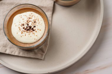 İtalyan çikolatası ve kahveli mus tatlı, yarı donmuş kremalı dondurma ve küçük bardaklarda kakao tozu.