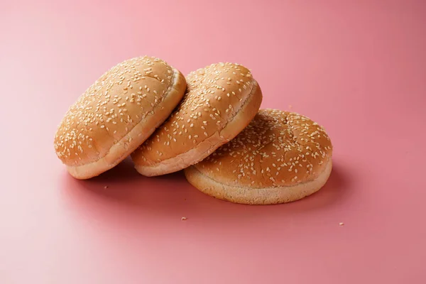 Három Fehér Búza Burger Zsemle Szezámmaggal Rózsaszín Varrat Nélküli Felületen — Stock Fotó
