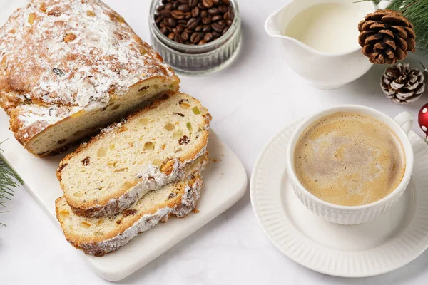 Beyaz çay tabağında kahve kapuçino ve mermer bir masada çalınmış noel pastası.