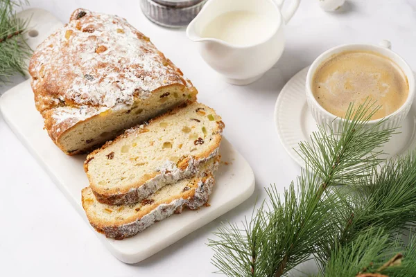 Beyaz çay tabağında kahve kapuçino ve mermer bir masada çalınmış noel pastası.