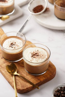 İtalyan çikolatası ve kahveli mus tatlı, yarı donmuş kremalı dondurma ve küçük bardaklarda kakao tozu.