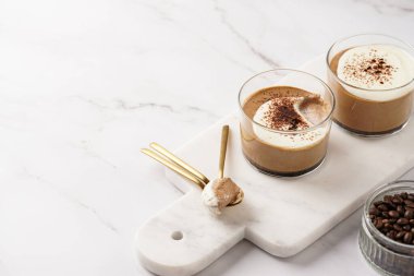 İtalyan çikolatası ve kahveli mus tatlı, yarı donmuş kremalı dondurma ve küçük bardaklarda kakao tozu.