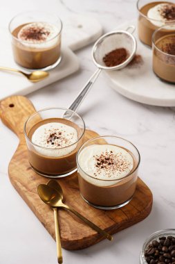 İtalyan çikolatası ve kahveli mus tatlı, yarı donmuş kremalı dondurma ve küçük bardaklarda kakao tozu.