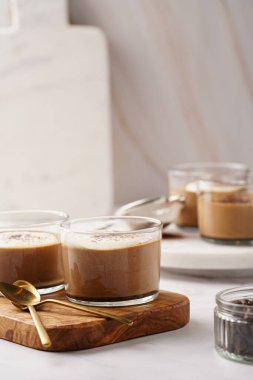 İtalyan çikolatası ve kahveli mus tatlı, yarı donmuş kremalı dondurma ve küçük bardaklarda kakao tozu.