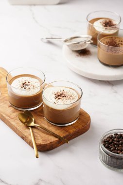 İtalyan çikolatası ve kahveli mus tatlı, yarı donmuş kremalı dondurma ve küçük bardaklarda kakao tozu.