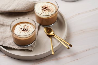 İtalyan çikolatası ve kahveli mus tatlı, yarı donmuş kremalı dondurma ve küçük bardaklarda kakao tozu.